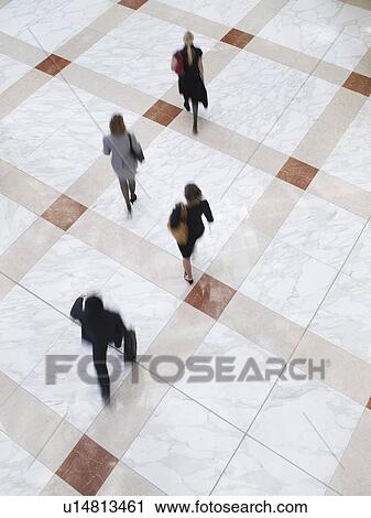 Stock Image - Business people walking elevated view long exposure. Fotosearch