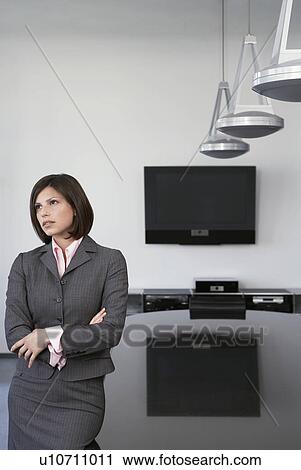 Business woman leaning against table in conference room View Large Photo Image Stock Image - Business woman leaning against table in conference room. Fotosearch