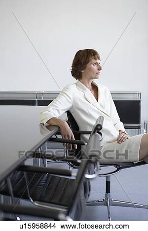 Business woman sitting beside conference table View Large Photo Image Picture - Business woman sitting beside conference table. Fotosearch