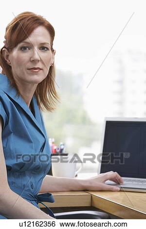 Business woman sitting in office View Large Photo Image Stock Photograph - Business woman sitting in office. Fotosearch