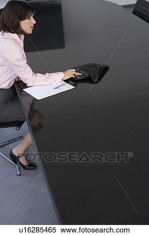 Business woman using calculator at conference room table View Large Photo Image Stock Photography - Business woman using calculator at conference room table. Fotosearch