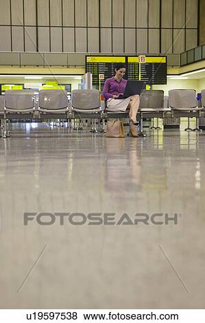 Business woman using laptop in airport lobby View Large Photo Image Stock Photo - Business woman using laptop in airport lobby. Fotosearch