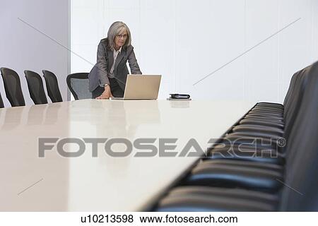 Stock Photo - Business woman using laptop in board room. Fotosearch