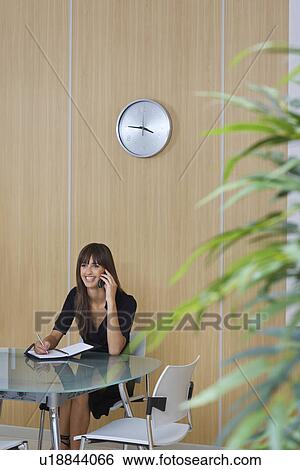 Business woman using mobile phone in conference room View Large Photo Image Stock Photograph - Business woman using mobile phone in conference room. Fotosearch