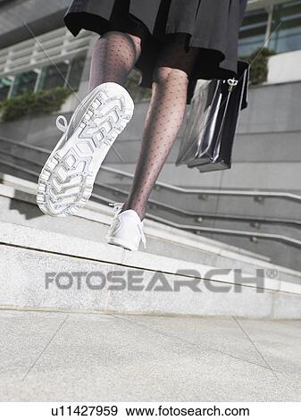 Business woman wearing running shoes walking up steps low section low angle view back view View Large Photo Image Stock Photo - Business woman wearing running shoes walking up steps low section low angle view back view. Fotosearch
