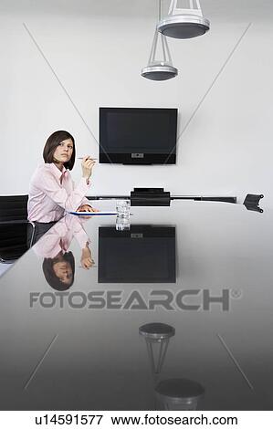 Business woman working at table in conference room View Large Photo Image Stock Photo - Business woman working at table in conference room. Fotosearch