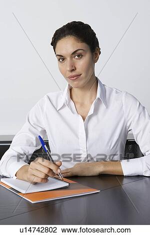 Business woman writing at desk in office portrait View Large Photo Image Stock Image - Business woman writing at desk in office portrait. Fotosearch