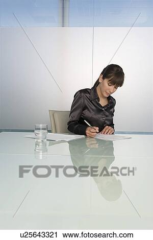Business woman writing at table in conference room View Large Photo Image Stock Image - Business woman writing at table in conference room. Fotosearch