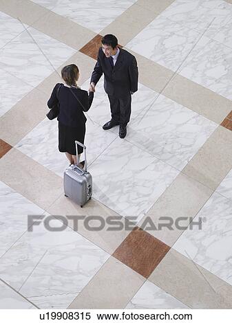 Businessman and businesswoman shaking hands elevated view View Large Photo Image Stock Photography - Businessman and businesswoman shaking hands elevated view. Fotosearch