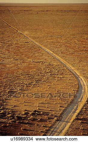 Picture - Car driving along desert road outback Australia. Fotosearch