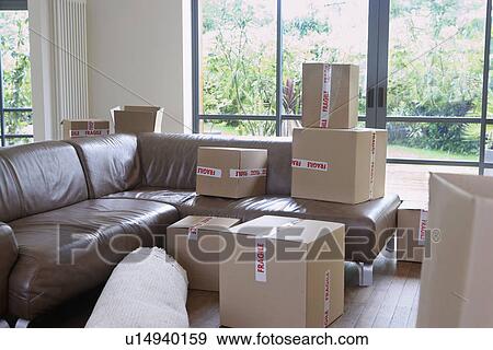 Cardboard boxes in living room of new home View Large Photo Image Stock Photo - Cardboard boxes in living room of new home. Fotosearch