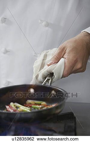 Chef cooking food in frying pan close-up View Large Photo Image Stock Image - Chef cooking food in frying pan close-up. Fotosearch