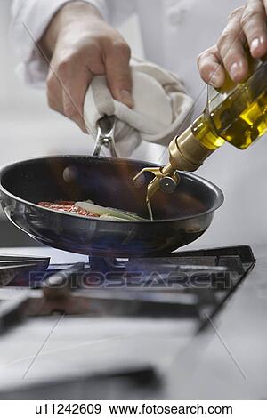 Chef cooking food in frying pan close-up View Large Photo Image Stock Photo - Chef cooking food in frying pan close-up. Fotosearch