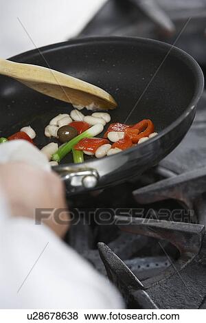 Chef cooking food in frying pan close-up View Large Photo Image Stock Photo - Chef cooking food in frying pan close-up. Fotosearch