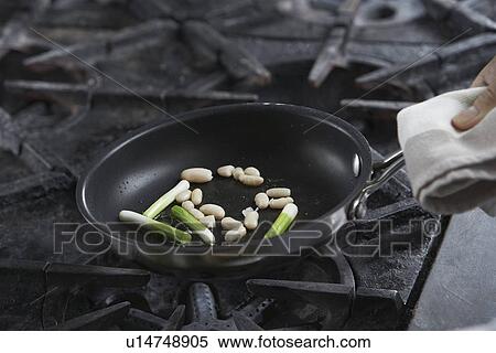 Chef cooking food in frying pan close-up View Large Photo Image Stock Photography - Chef cooking food in frying pan close-up. Fotosearch