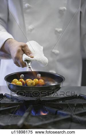 Chef cooking food in frying pan mid-section View Large Photo Image Stock Photography - Chef cooking food in frying pan mid-section. Fotosearch