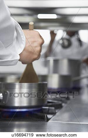 Chef cooking in kitchen close-up of stove View Large Photo Image Stock Photo - Chef cooking in kitchen close-up of stove. Fotosearch