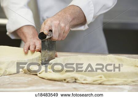 Chef cutting dough close-up View Large Photo Image Stock Photo - Chef cutting dough close-up. Fotosearch