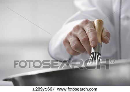 Stock Photo - Chef mixing ingredients in bowl close-up. Fotosearch