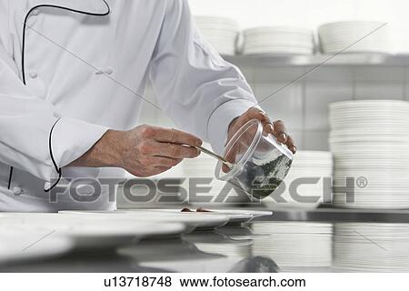 Stock Photo - Chefs preparing salad in kitchen mid section. Fotosearch