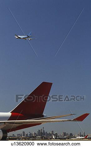 Close-up of airplane's tail fin flying plane in background View Large Photo Image Stock Image - Close-up of airplane's tail fin flying plane in background. Fotosearch