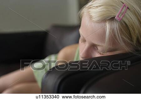 Stock Image - Close-up of girl (7-9) sleeping on sofa. Fotosearch