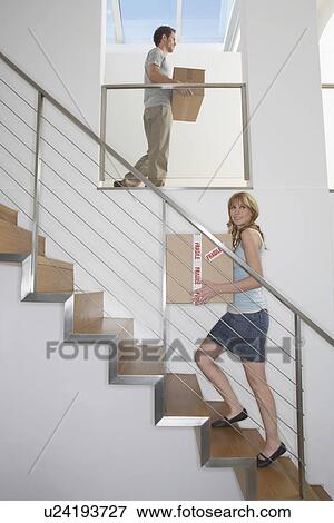 Couple carrying boxes upstairs in new home View Large Photo Image Stock Photo - Couple carrying boxes upstairs in new home. Fotosearch