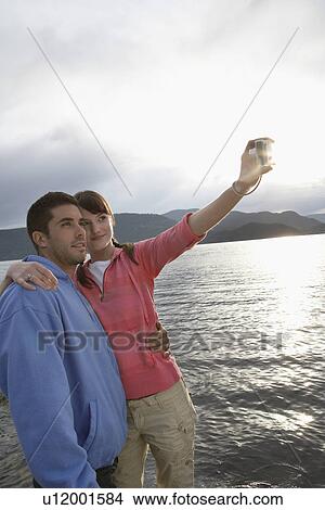 Picture - Couple embracing at ocean. Fotosearch