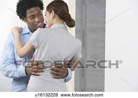 Stock Photo - Couple embracing indoors. Fotosearch