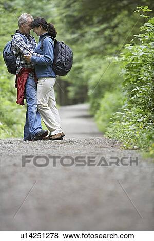 Couple embracing on forest road side view View Large Photo Image Stock Photo - Couple embracing on forest road side view. Fotosearch
