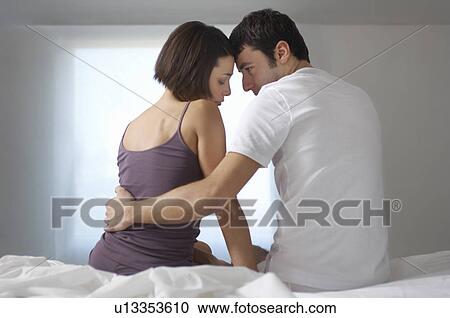 Couple embracing sitting on bed back view View Large Photo Image Stock Image - Couple embracing sitting on bed back view. Fotosearch