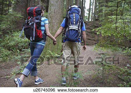 Couple holding hands walking in forest View Large Photo Image Stock Photograph - Couple holding hands walking in forest. Fotosearch