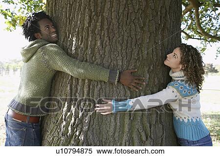 Couple hugging tree View Large Photo Image Stock Photography - Couple hugging tree. Fotosearch