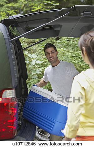 Couple loading car in countryside View Large Photo Image Stock Photograph - Couple loading car in countryside. Fotosearch