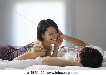 Stock Image - Couple lying on bed. Fotosearch
