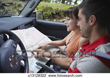 Couple observing map in car View Large Photo Image Stock Image - Couple observing map in car. Fotosearch