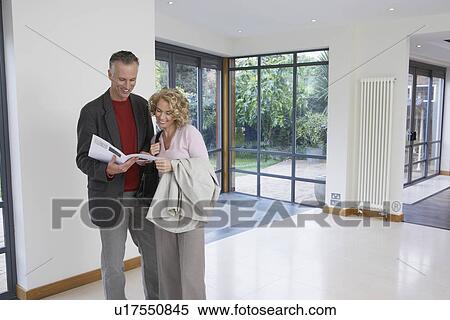 Couple reading brochure in new property View Large Photo Image Stock Photography - Couple reading brochure in new property. Fotosearch