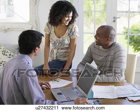 Couple sitting at dining table with financial advisor elevated view View Large Photo Image Stock Image - Couple sitting at dining table with financial advisor elevated view. Fotosearch