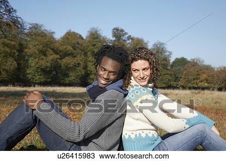 Couple sitting back to back in field side view View Large Photo Image Stock Image - Couple sitting back to back in field side view. Fotosearch