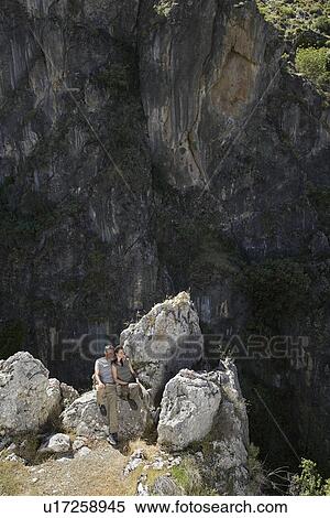 Couple sitting on mountain top elevated view View Large Photo Image Stock Photography - Couple sitting on mountain top elevated view. Fotosearch