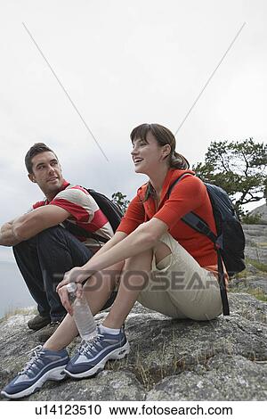 Couple sitting on rocks at ocean View Large Photo Image Stock Image - Couple sitting on rocks at ocean. Fotosearch