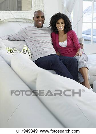 Couple sitting on sofa portrait View Large Photo Image Stock Photo - Couple sitting on sofa portrait. Fotosearch