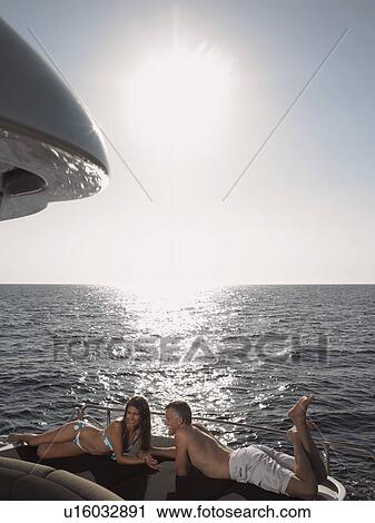Couple Sunbathing on Boat View Large Photo Image Stock Image - Couple Sunbathing on Boat. Fotosearch