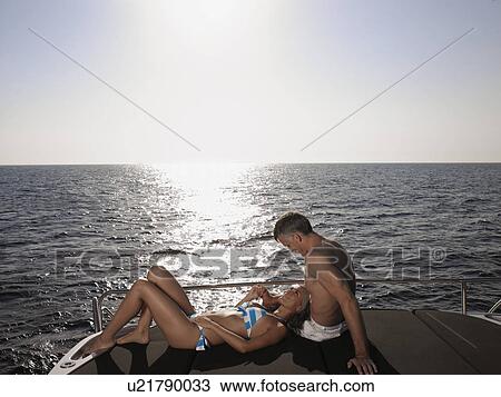 Couple Sunbathing on Boat View Large Photo Image Stock Image - Couple Sunbathing on Boat. Fotosearch
