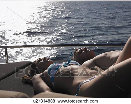 Couple Sunbathing on Boat View Large Photo Image Stock Photo - Couple Sunbathing on Boat. Fotosearch