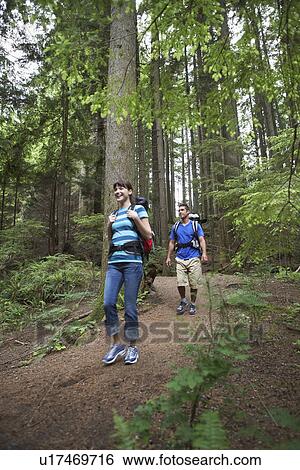 Stock Photograph - Couple walking in forest. Fotosearch