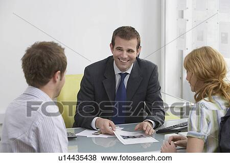 Stock Photo - Couple with real estate agent in office. Fotosearch