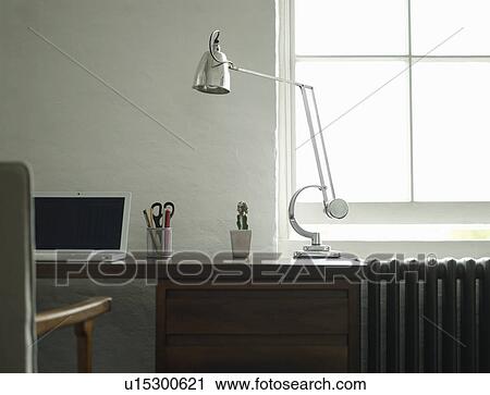 Stock Image - Desk with laptop and lamp. Fotosearch
