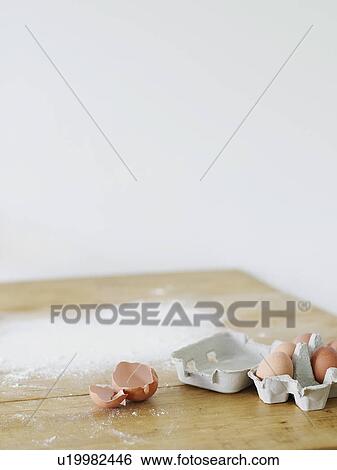 Stock Photograph - Eggs and flour scattered on table top. Fotosearch