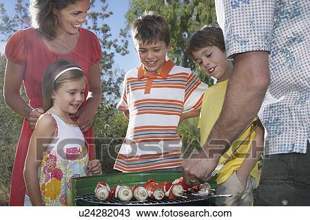 Family with three children (6-11) grilling in garden View Large Photo Image Stock Image - Family with three children (6-11) grilling in garden. Fotosearch